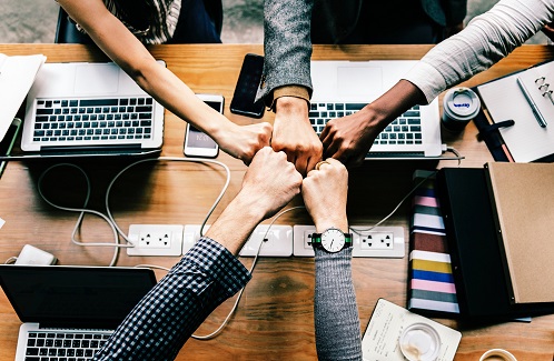 Trois employés assis face à des ordinateurs répondent aux appels téléphoniques de clients